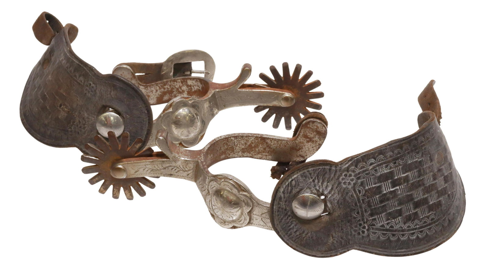 (PAIR) CROCKETT BLOSSOM PATTERN WESTERN SPURS: (pair) Western cowboy spurs, marked Crockett, outside heel band mounted with engraved silver blossom, 2 1/8" rowels, sixteen points, on worn tooled leather straps with loss, metal oxidized, yoke: appr