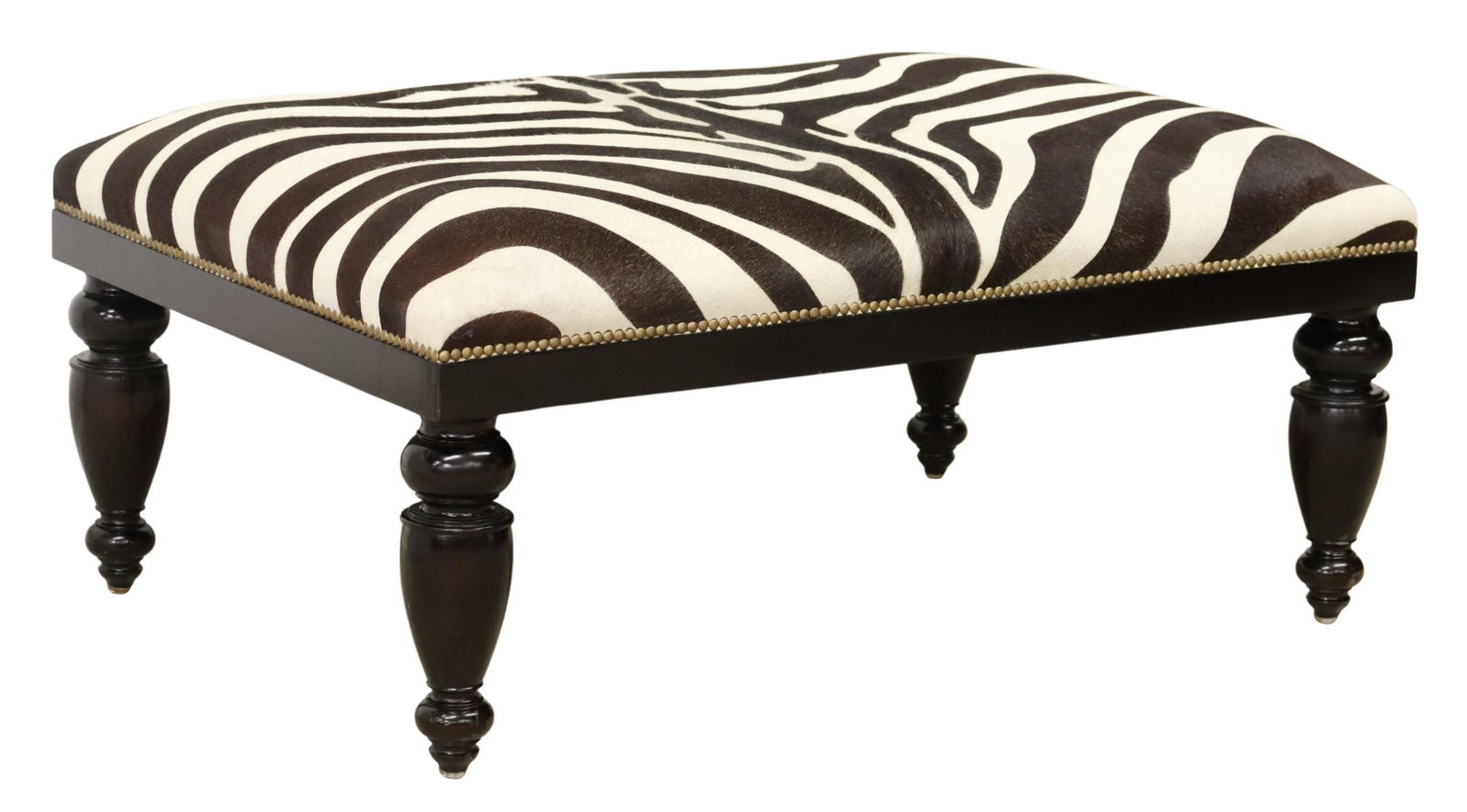 LARGE OLY STUDIO ZEBRA PATTERN COWHIDE OTTOMAN: Contemporary ottoman/ footstool, Oly Studio, 21st c., cowhide upholstery with printed zebra pattern, black painted frame, rising on turned legs, approx 20"h, 44"w, 30"d Start Price: $200.00