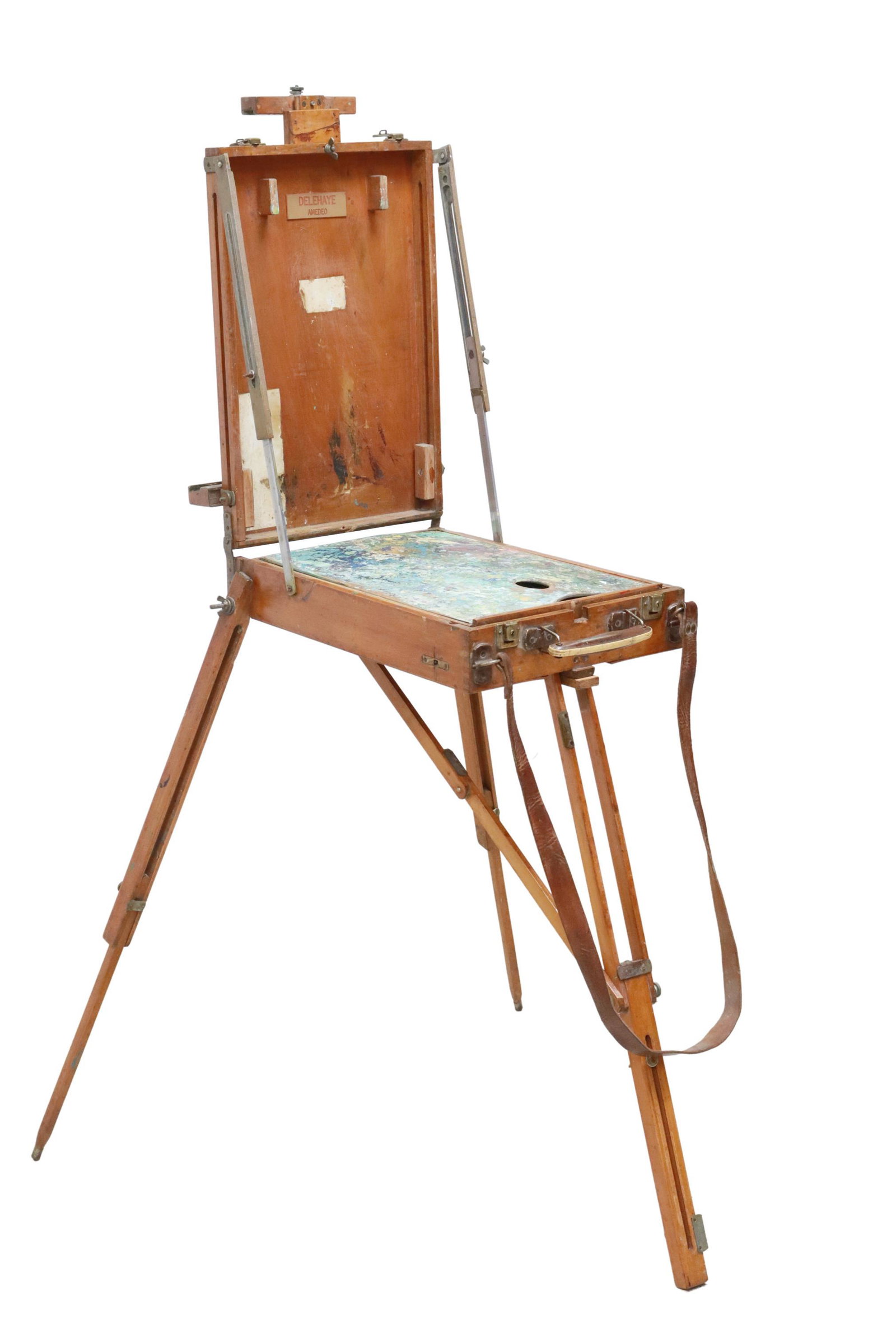 FRENCH CONVERTIBLE TRAVELING ARTIST'S EASEL TABLE: French convertible traveling artist's easel, early 20th c., rectangular case with rolled top handle and flat leather shoulder strap, adjustable height easel over hinged top, opening to single drawer f