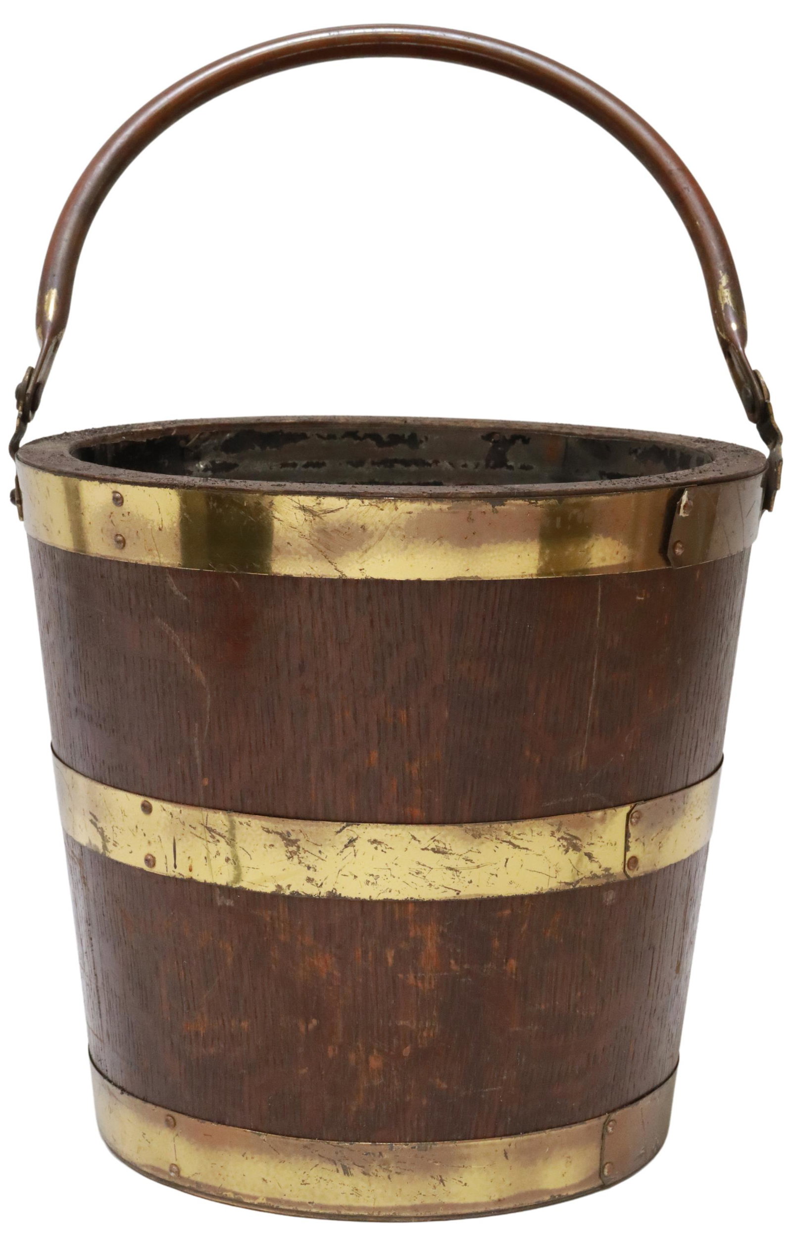 BRITISH BRASS-BANDED OAK PEAT BUCKET: British brass-banded oak peat bucket, late 19th/ early 20th c., swing bail handle, brass banding, metal-lined interior, approx 12"h (handle down), 13"diam, 6.25lbs Start Price: $80.00