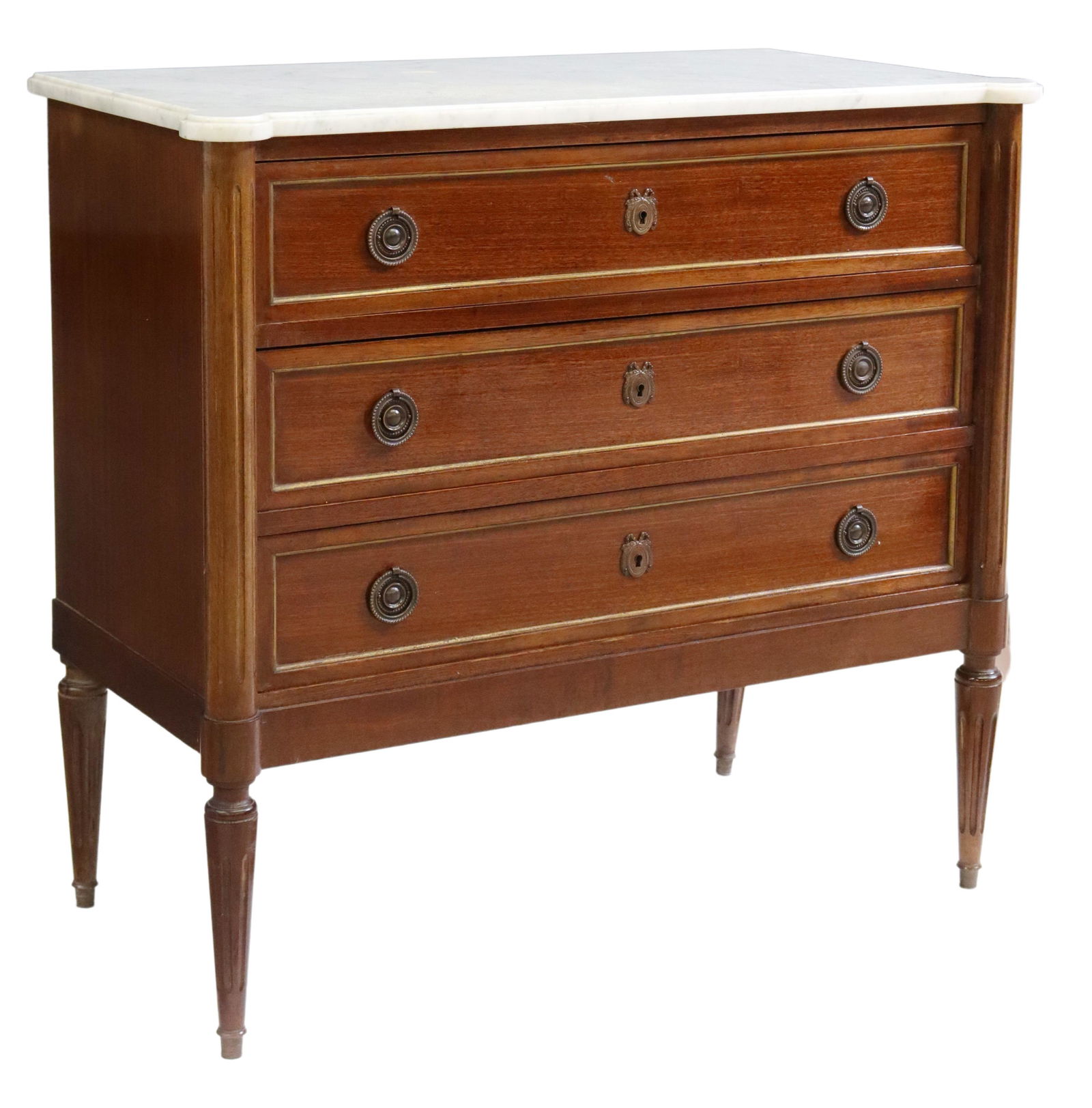 FRENCH LOUIS XVI STYLE MARBLE-TOP MAHOGANY COMMODE: French Louis XVI style mahogany commode, late 19th/ early 20th c., having shaped marble top, over three drawers, flanked by fluted side supports, rising on tapered legs, approx 31.5"h, 34.25"w, 17.5"d