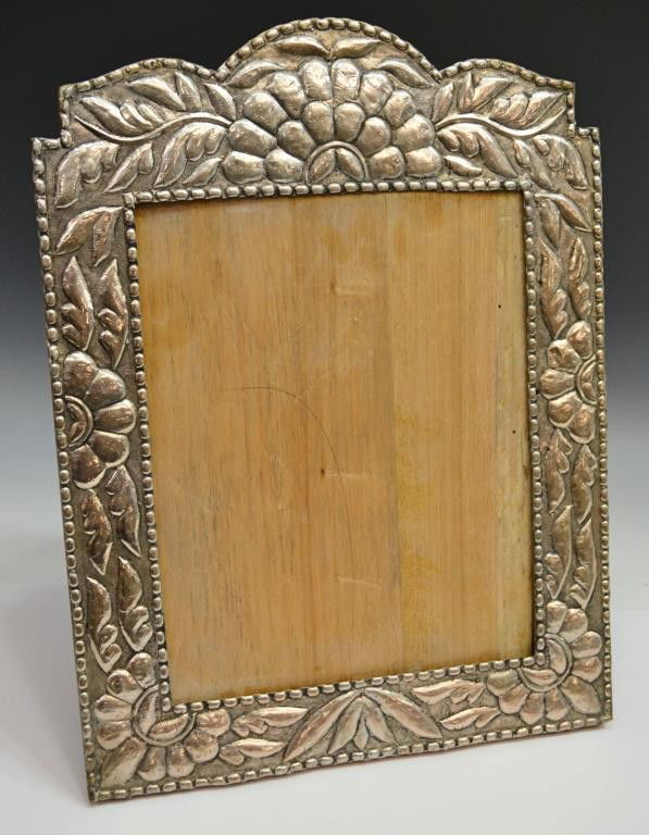 ANTIQUE SPANISH COLONIAL SYTLE 900 SILVER FRAME: Antique Spanish Colonial style 900 silver picture frame, the wood frame mounted with repousse 900 silver sheet in an elaborate foliate and floral motif, sight: 12"h, 9.5"w, overall: 18.25"h, 14"w, 2.7