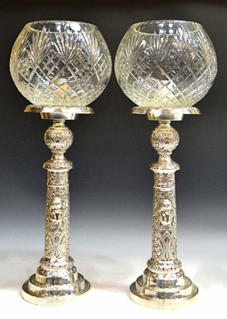 LARGE CHERUB SILVER PLATE & CUT GLASS TABLE LAMPS: (lot of 2) Large table lamps, each silver plate standard on a stepped base, elaborately decorated with relief cherub masks amid profuse foliate motifs, colorless cut glass globes, one retaining tag 'l