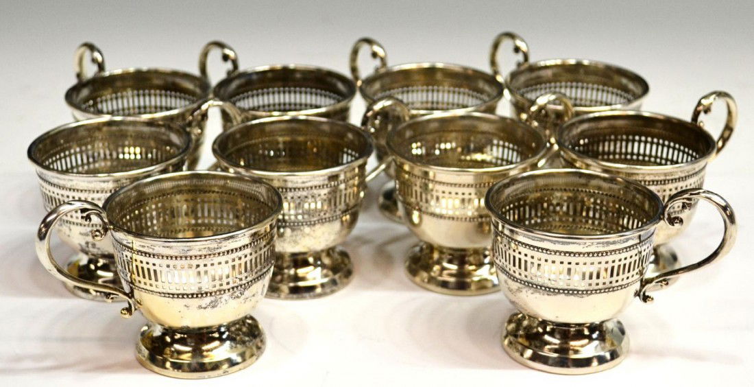 SET OF 10 STERLING SILVER DEMITASSE CUP FRAMES: (set of 10) Sterling silver demitasse cup frames, reticulated borders and scrolled handle rising on a pedestal foot, marked sterling underfoot, 8.64ozt total Start Price: $100.00