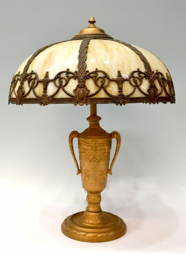 VINTAGE AMERICAN SLAG GLASS TABLE LAMP: Slag glass and cast gilt metal table lamp, c. 1920's, the domed shade set with eight panels, ornate vasiform standard in gilt paint with some loss and wear, raised on a circular foot, overall: 25"h, s
