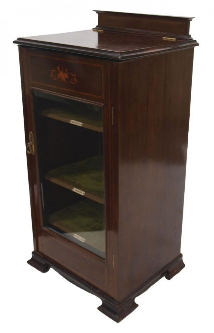 MAHOGANY MUSIC CABIINET, MUSIC STAND & SHELVES: Mahogany finish music cabinet, 20th c, having a crest rail over a banded inlaid top, when open displays a sheet music stand, a single front door with contrasting inlaid wood musical instruments over b