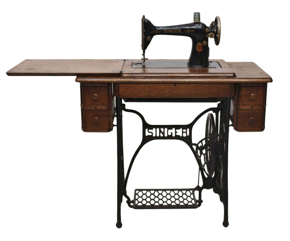 VINTAGE SINGER TREADLE SEWING MACHINE: Singer treadle sewing machine, oak table having four drawers and central drop drawer in three sections, all raised on a Singer iron base, lacking metal plate at bobbin, 29"h, 34"w, 16"d Start Price: $