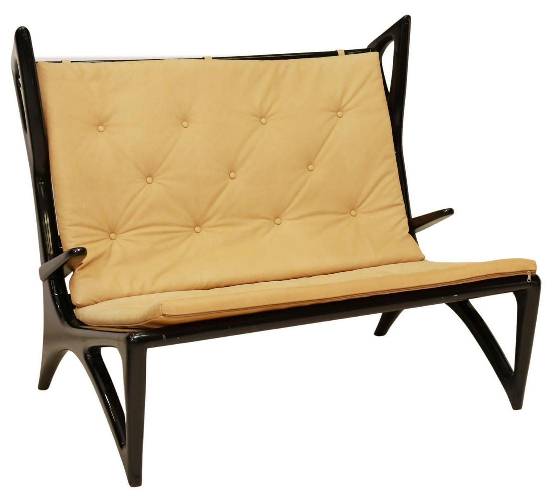 ITALIAN MID-CENTURY MODERN EBONIZED SETTEE: Italian mid-century modern settee/ loveseat, c.1950s, sculptural wingback frame in an ebonized finish, button-tufted leather cushions, rising on tapered legs, wear to finish, approx 42"h, 50"w, 33"d *