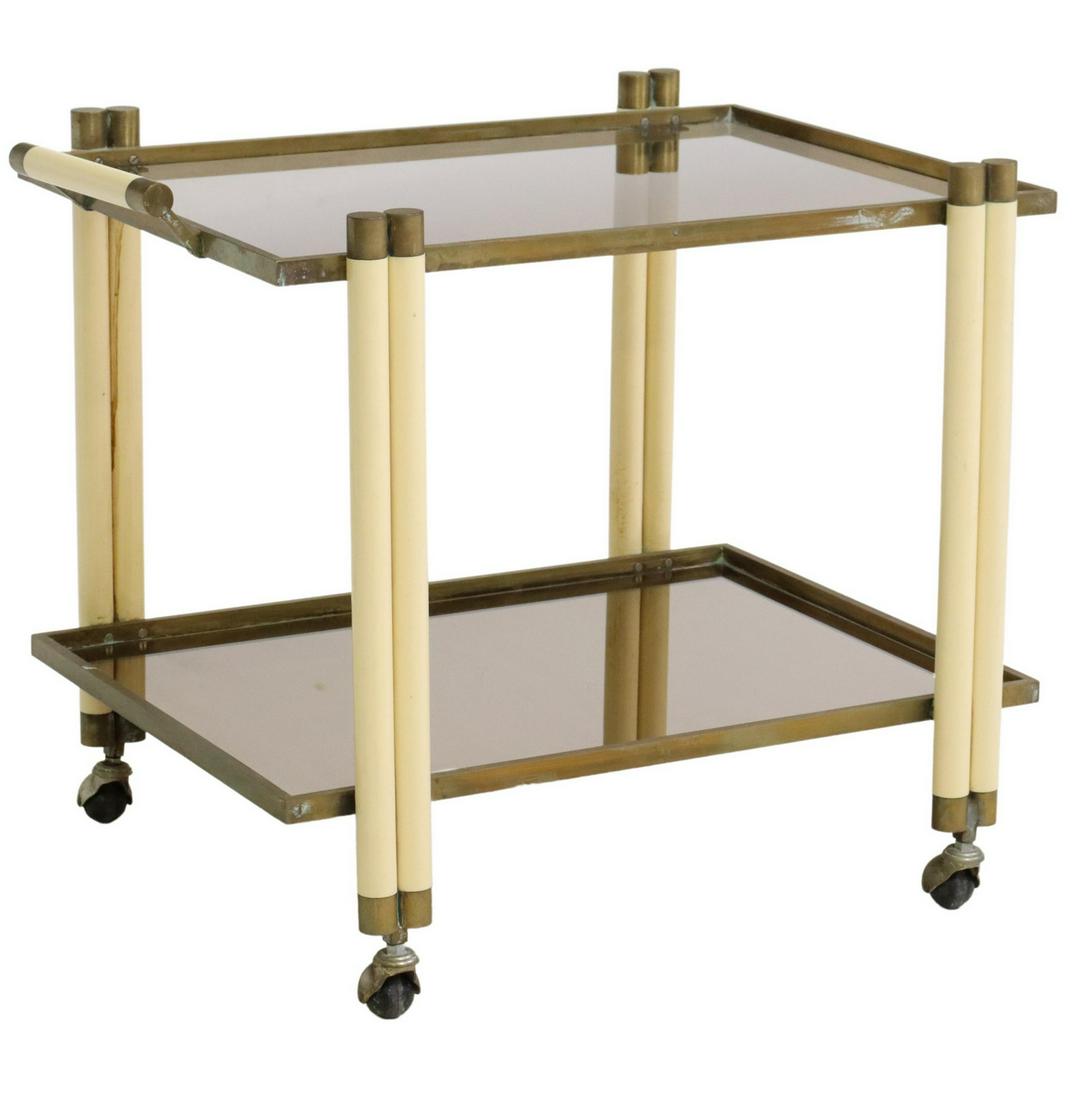 ITALIAN MODERN TWO-TIER SERVICE BAR CART: Italian modern two-tier service/ bar cart, in the manner of Tommaso Barbi (Italian, 20th c.), c.1970s, having smoked glass top, brass frame with plastic uprights and handle, above mirrored bottom shel