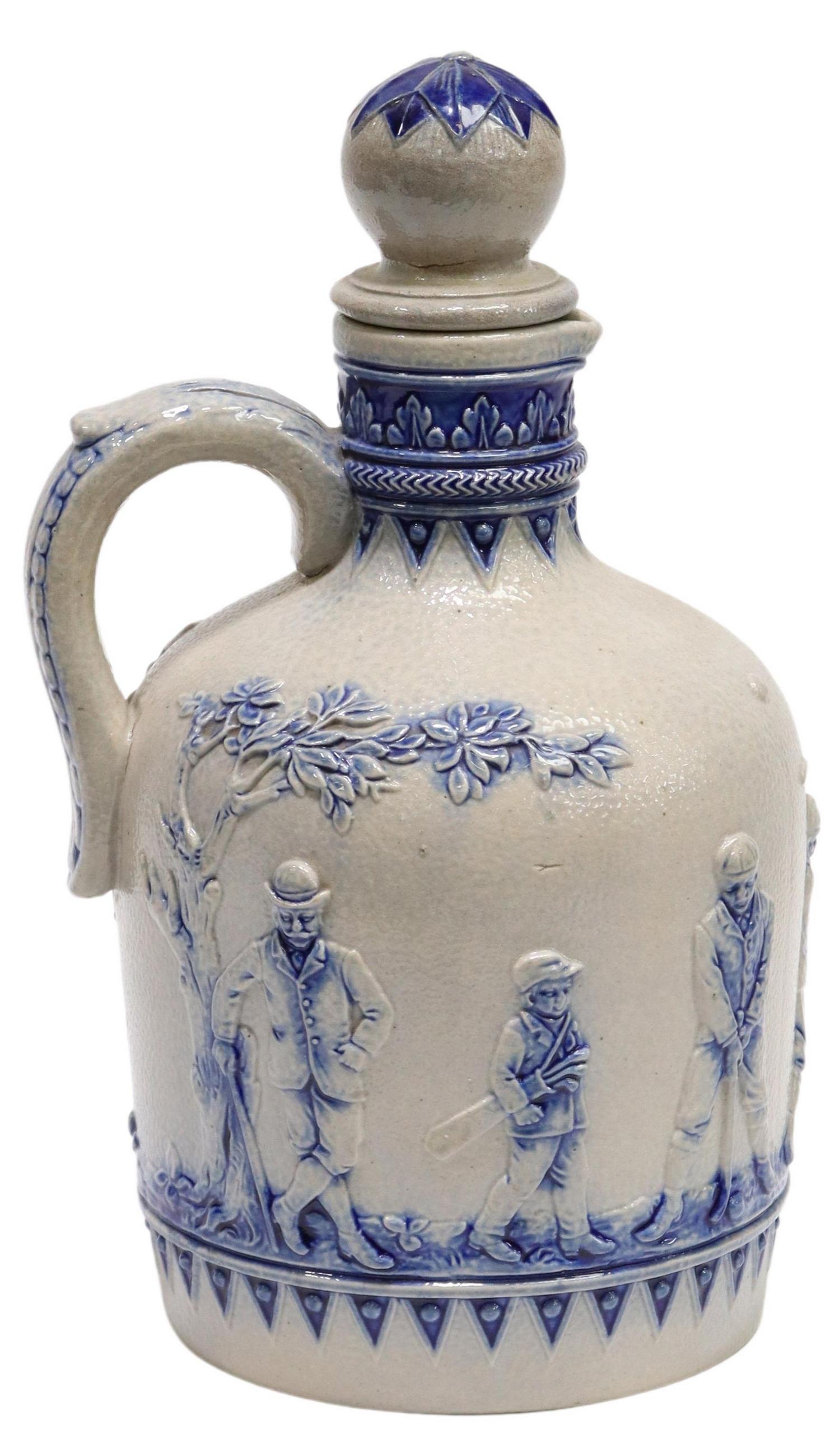 GERMAN SIMON PETER GERZ COBALT STONEWARE GOLF JUG: German stoneware jug, Simon Peter Gerz, early 20th c., having raised golfer design in cobalt blue, maker's mark underfoot, approx 9"h, 4.5"diam, 1.1lbs Start Price: $200.00