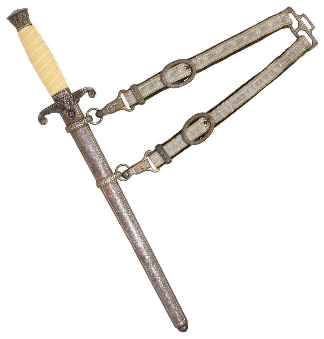 GERMAN NAZI DRESS DAGGER, SCABBARD & HANGER: German Nazi dagger, a 10" unmarked steel blade ending at the aluminum guard with a Nazi eagle and swastika, a white celluloid handle, the aluminum pommel with oak leaves, complete with a steel pebbled