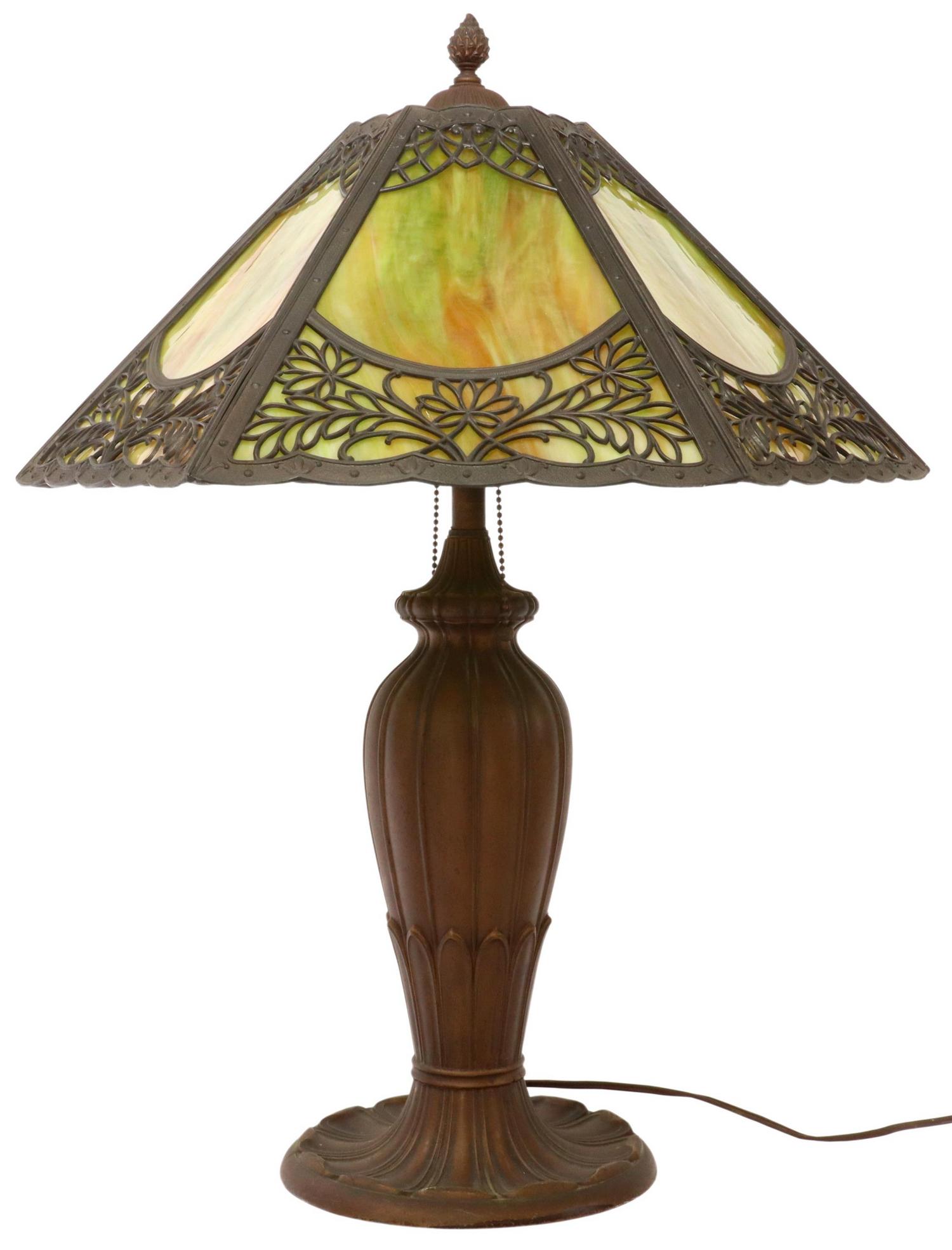 AMERICAN SLAG GLASS TWO-LIGHT TABLE LAMP: American slag glass table lamp, early 20th c., hexagonal shade with slag glass panes, pierced foliate overlay, two lights, metal base in a bronze patina, approx 25.5"h, 20"diam, 22lbs Start Price: $10