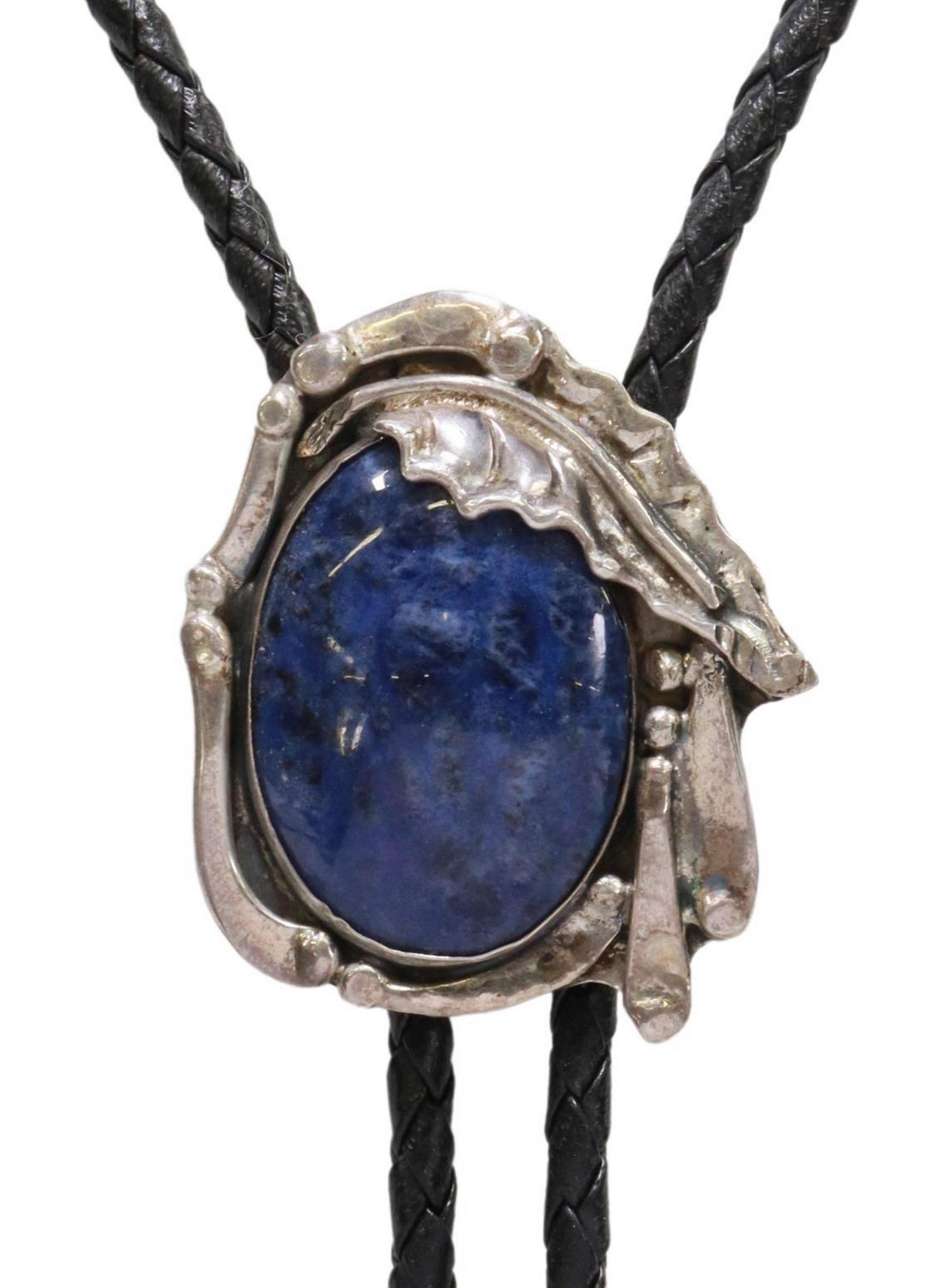 SOUTHWEST STYLE SILVER & BLUE SODALITE BOLO TIE: Southwest style silver (content unknown) bolo tie, Stanley Leo "Stan" Davidson (Massachusetts, 1933-2012), blue stone cabochon, likely sodalite, silver bolo tips, on braided black leather cord, bolo o