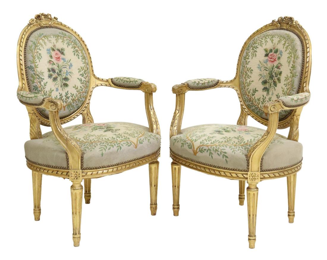(2) FRENCH LOUIS XVI STYLE GILTWOOD FAUTEUILS: (pair) French Louis XVI style giltwood armchairs, 20th c., having floral crest, over oval medallion back with ribbon twist molding, scrolled handholds, floral needlepoint upholstery, nailhead trim, ri