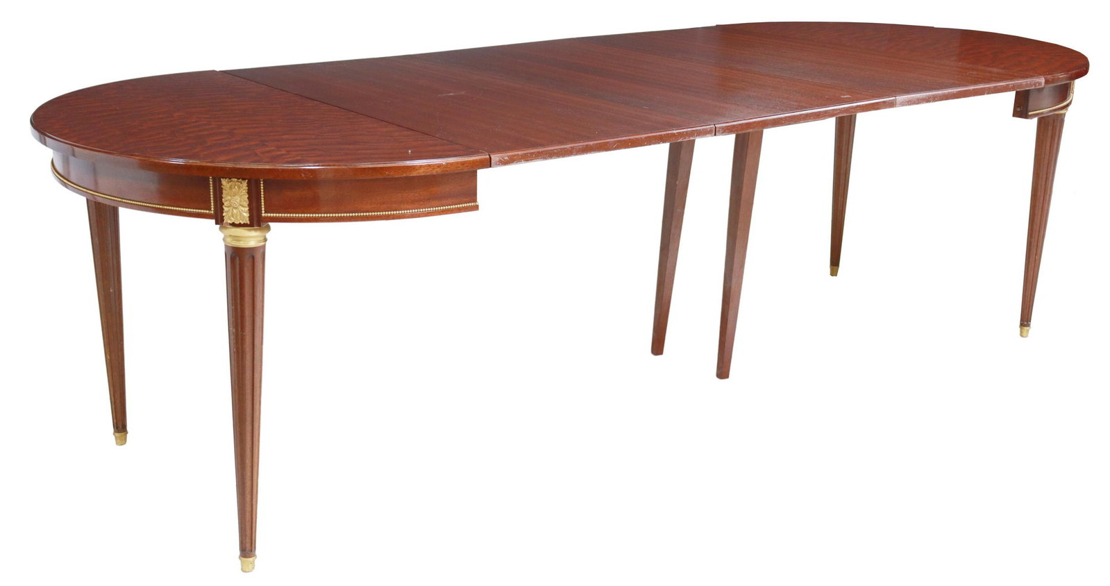 FRENCH LOUIS XVI STYLE MAHOGANY DINING TABLE: French Louis XVI style mahogany extension table, 20th c., figured tabletop, apron with gilt metal beaded trim, foliate bosses, rising on tapering fluted legs, accompanied by (three) 19.75" leaves, app