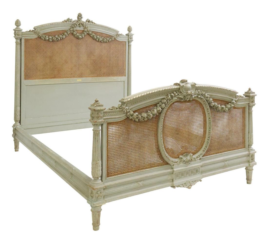 MAISON LALANDE LOUIS XVI STYLE PAINTED & CANE BED: French Louis XVI style painted bed, Maison Lalande, 34 Rue de Charenton, Paris, late 19th/ early 20th c., carved ribbon crest, floral garlands overlaying the double cane panel, fluted posts with acant
