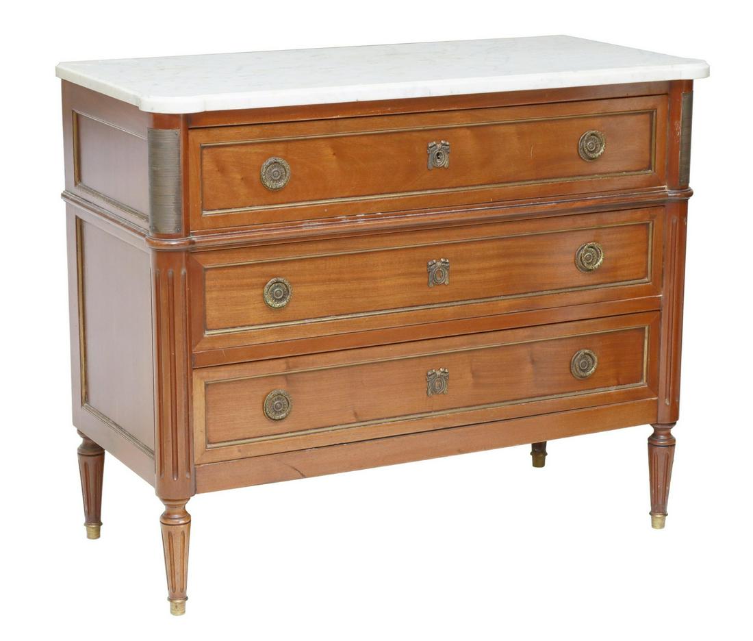 FRENCH LOUIS XVI STYLE MARBLE-TOP MAHOGANY COMMODE: French Louis XVI style mahogany commode, 20th c., having shaped marble top, fitted with three drawers, gilt metal banding, flanked by fluted supports, rising on tapered legs, ending on capped feet, ap