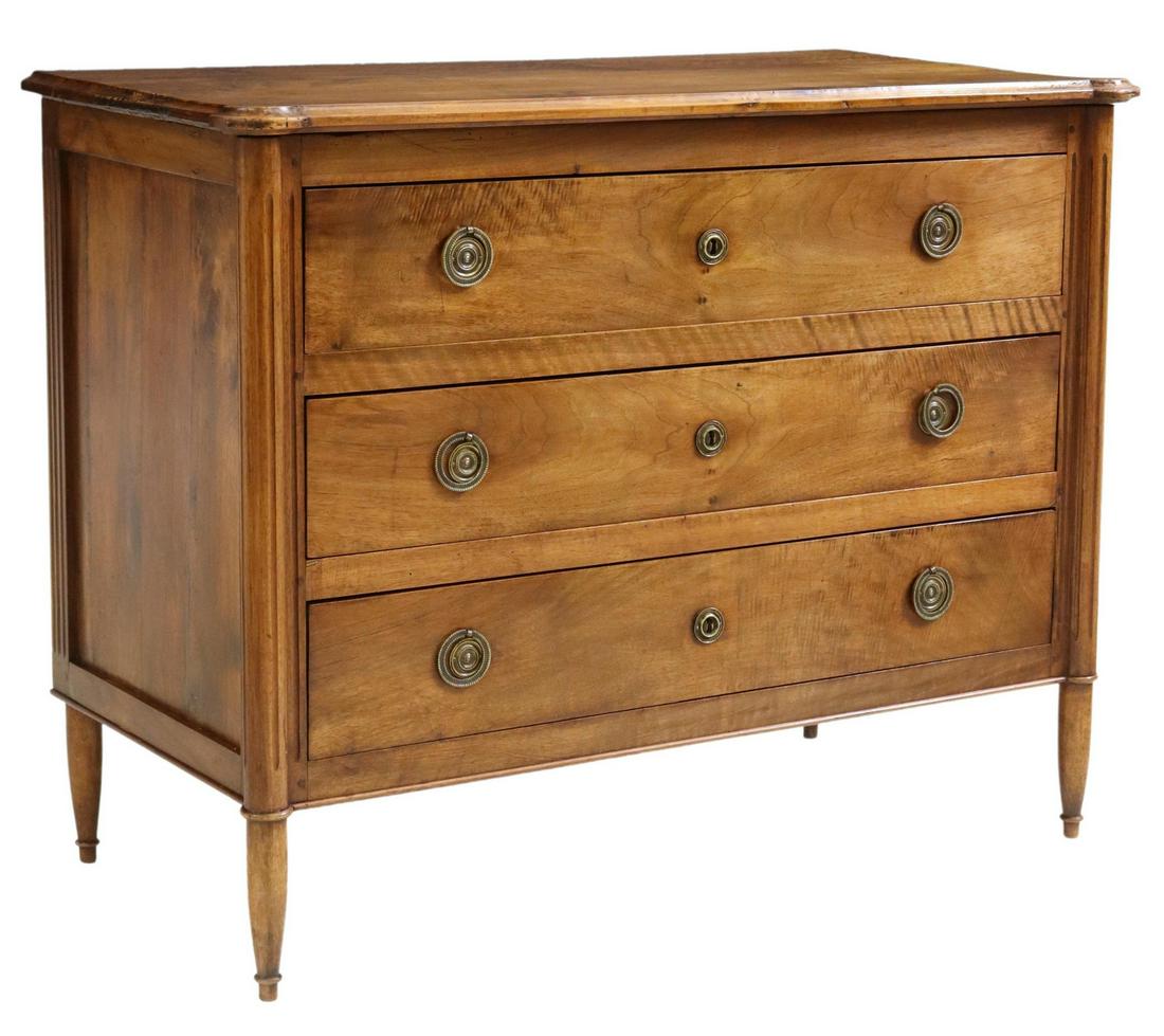 FRENCH LOUIS XVI STYLE WALNUT THREE-DRAWER COMMODE: French Louis XVI style walnut commode, early 20th c., three drawers framed by fluted corner posts, rising on tapered legs, approx 34.25"h, 44"w, 21.25"d Start Price: $350.00