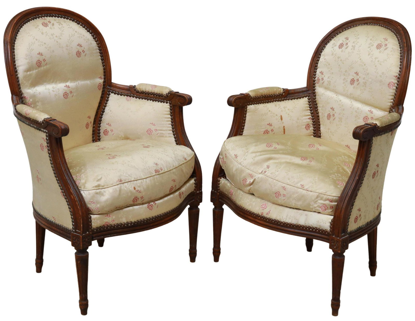 (2) FRENCH LOUIS XVI STYLE UPHOLSTERED BERGERES: (pair) French Louis XVI style armchairs,19th c., rounded back, in a floral upholstery, with nailhead trim, scrolled handholds, rising on fluted and tapered legs, approx 34.5"h, 23"w, 20.5"d, seat heig