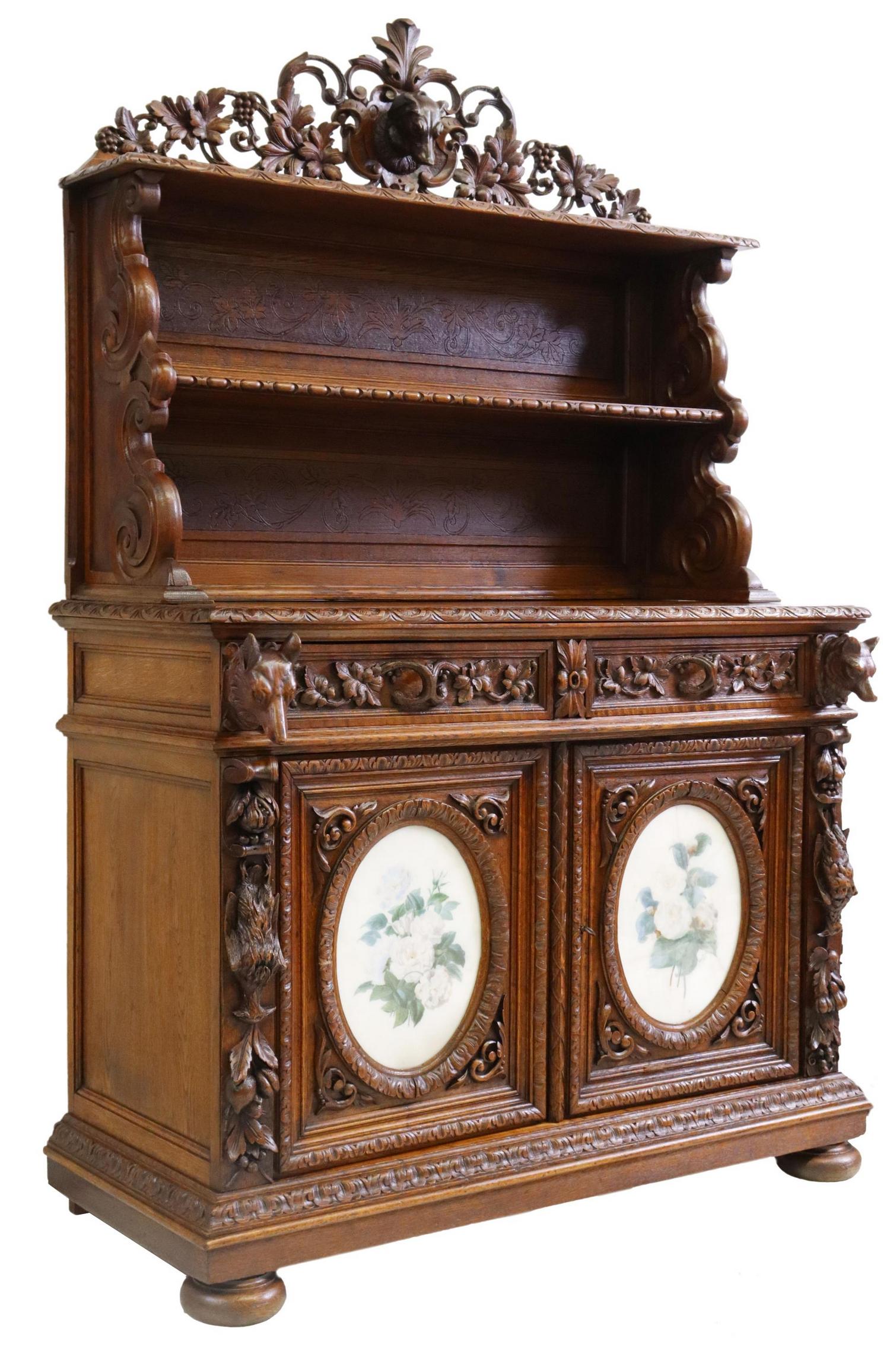 FRENCH RENAISSANCE REVIVAL CARVED OAK SIDEBOARD: French Renaissance Revival carved oak sideboard, 19th c., having scrolling foliate crest, centering protruding hound mask, two open shelves, over two drawers, above two lower cabinets, faced with flor