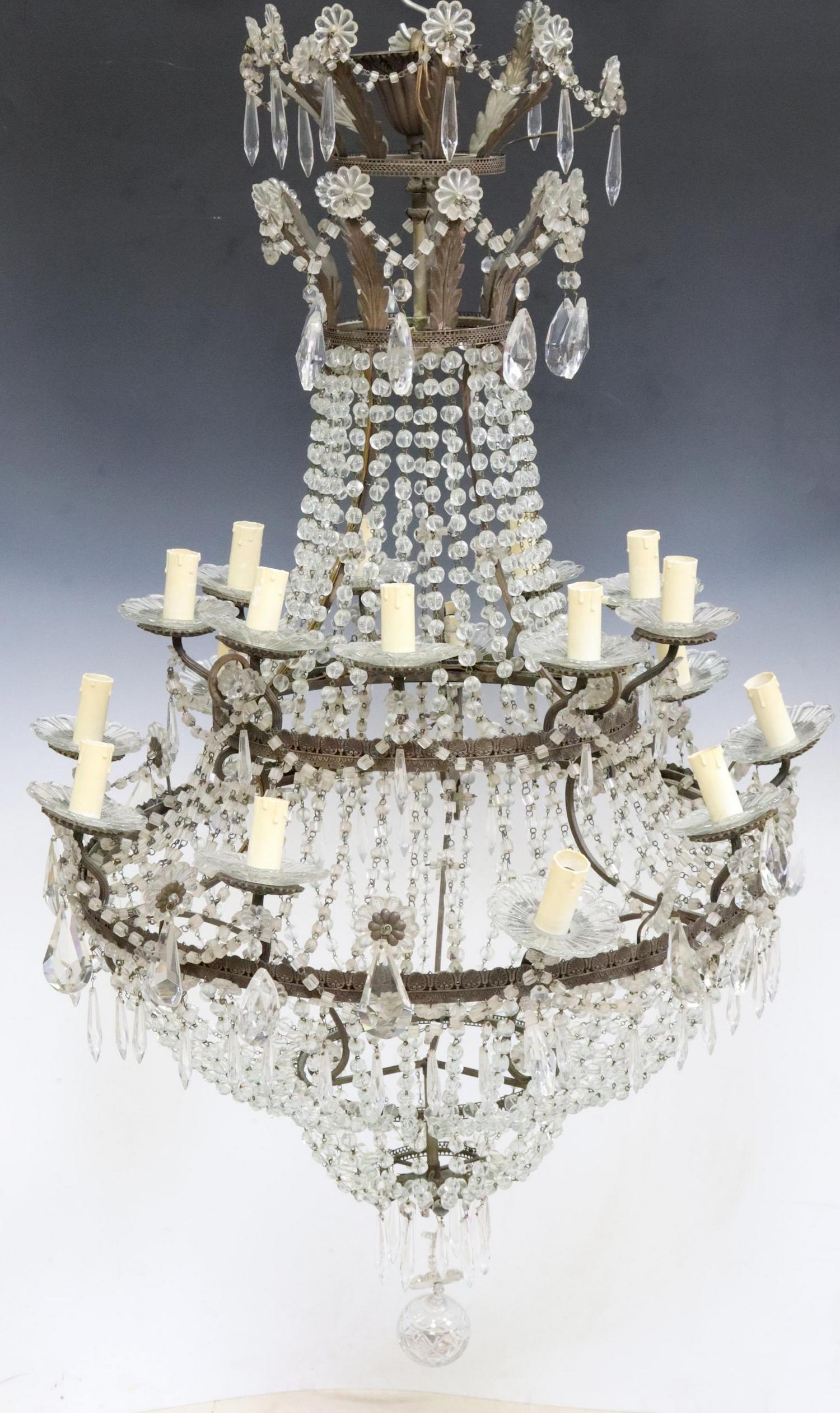 EMPIRE STYLE SAC-A-PEARL 18-LIGHT CHANDELIER: Empire style eighteen-light "Sac-A-Pearl" chandelier, 20th c., having two foliate tiers, over cascading crystal drops, issuing two tiers of floral crystal bobeches, terminating in faux candle covers, 