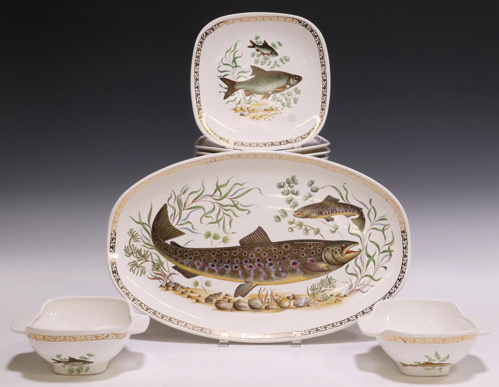 (27) FRENCH LONGCHAMPS PORCELAIN FISH SERVICE: (lot of 27) French porcelain fish service, Longchamps, with parcel gilt border, including: (1) serving platter, approx 16.75"l, 10 5/8"w, (2) square-handled sauce bowls, approx 2.75"h, 6 5/8"w, 5.25"d