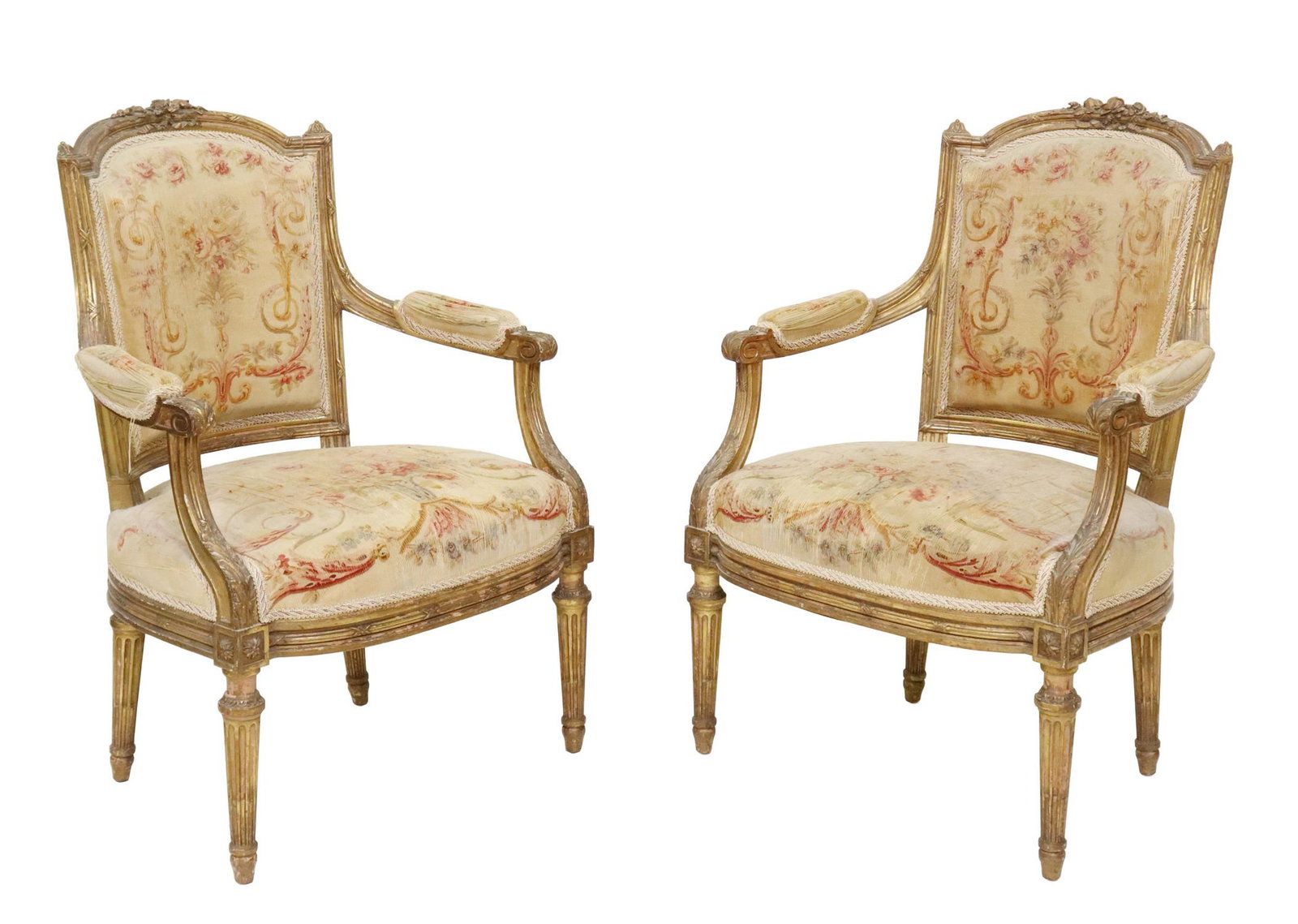 (2) LOUIS XVI STYLE UPHOLSTERED GILTWOOD FAUTEUILS: (pair) Louis XVI style giltwood armchairs, late 19th c., floral crest, acanthus scroll handholds, worn tapestry upholstery with floral pattern, rising on tapering fluted legs, approx 36.5"h, 25"w, 21.