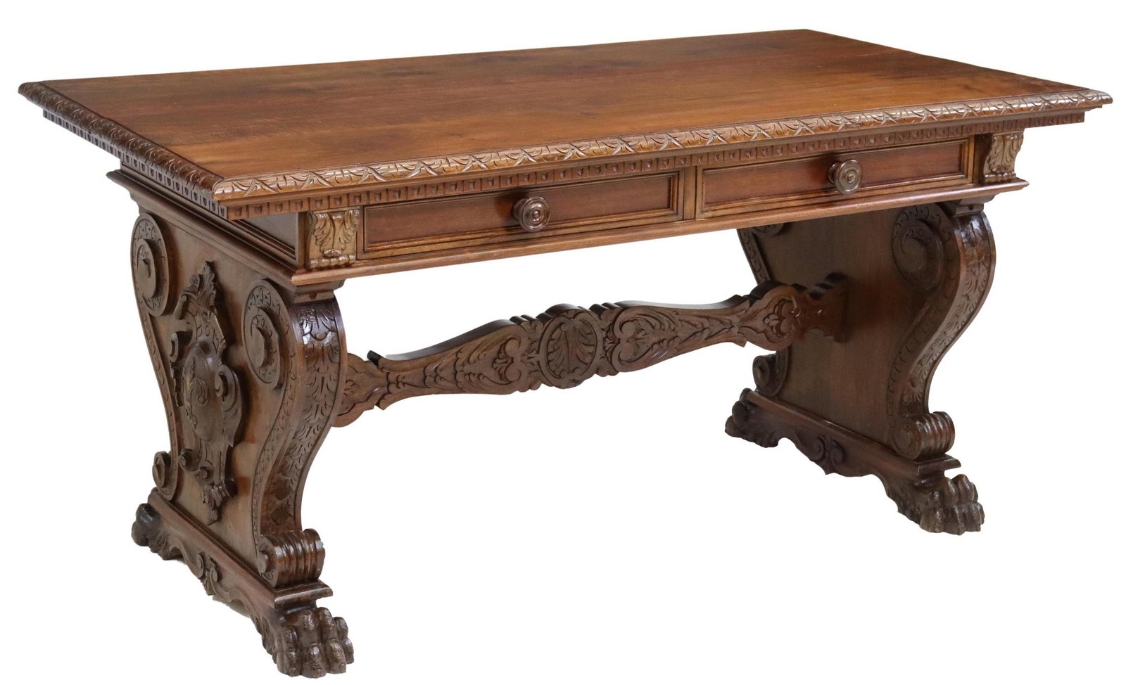 ITALIAN RENAISSANCE REVIVAL CARVED WALNUT DESK: Italian Renaissance Revival carved walnut writing table, early 20th c., having foliate border, fitted with two drawers, rising on shaped cartouche supports, joined with carved stretcher, ending on paw