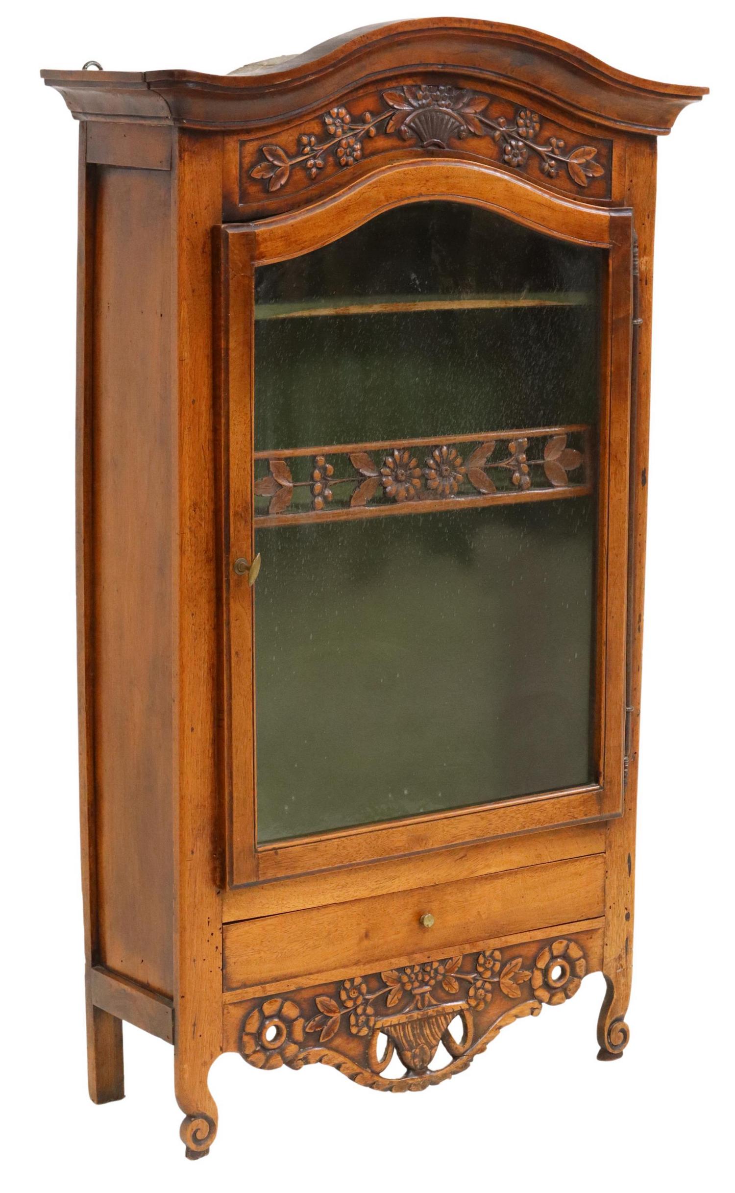 FRENCH PROVINCIAL LOUIS XV STYLE WALNUT VITRINE: French Provincial Louis XV style walnut wall-mounted vitrine/ display case, 19th c., having molded cornice, over floral crest, glazed door, opening to lined shelved interior, above pierced apron, risi