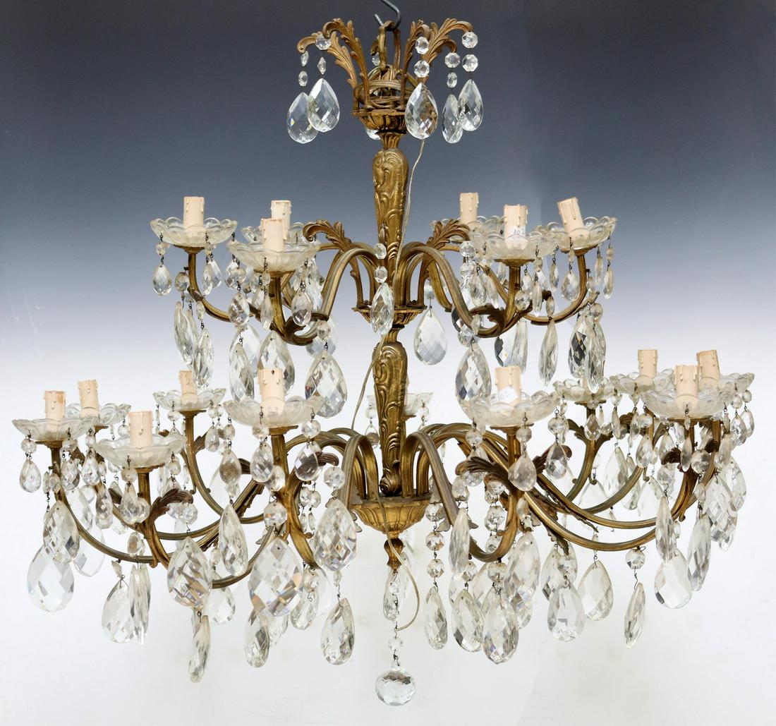 ITALIAN GILT METAL & CRYSTAL 17-LIGHT CHANDELIER: Italian gilt metal and crystal seventeen-light chandelier, 20th c., having tapered rocaille standard, issuing foliate scrolled arms, crystal floral bobeches, terminating in faux candle covers, hung wi