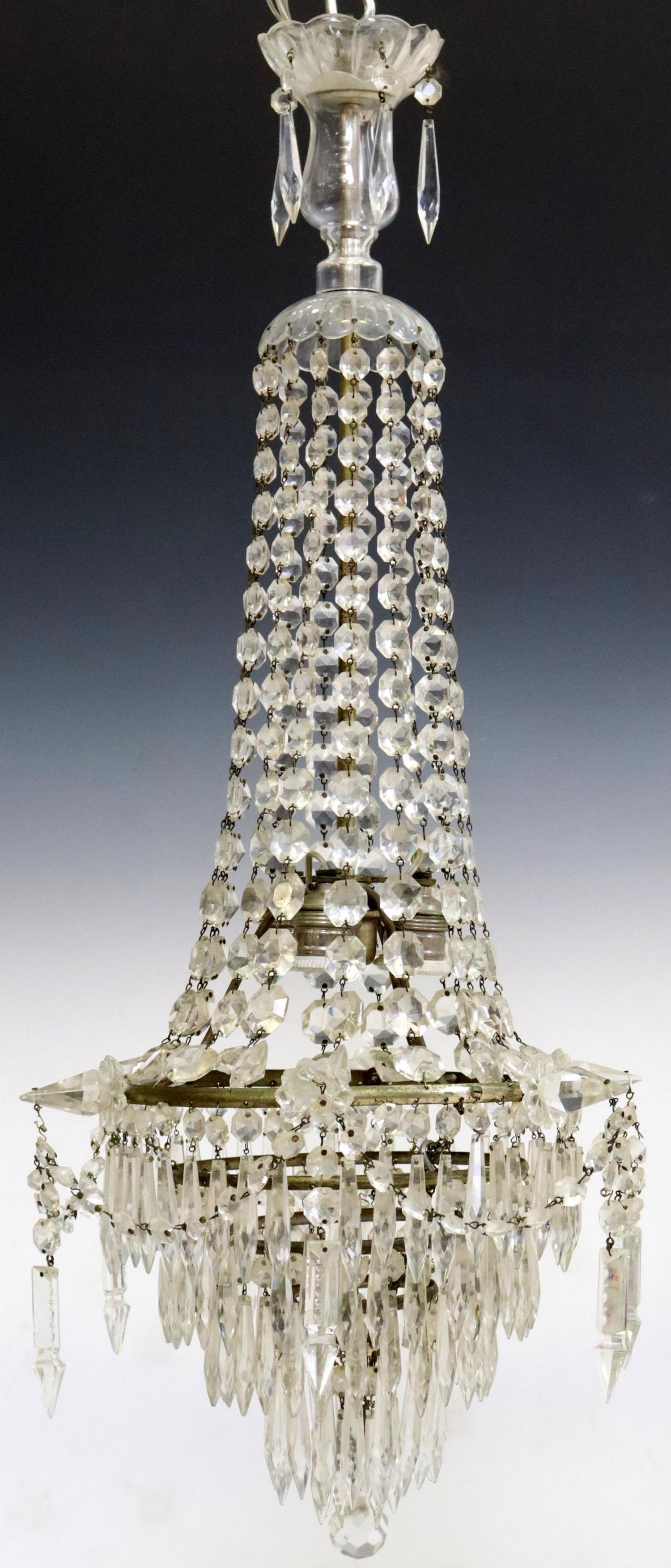 CRYSTAL WEDDING CAKE THREE-LIGHT CHANDELIER: Continental crystal three-light chandelier, 20th c., molded glass crest, over hanging crystals, tired wedding cake form lower section, centering three interior lights, hung with prisms and crystal swa