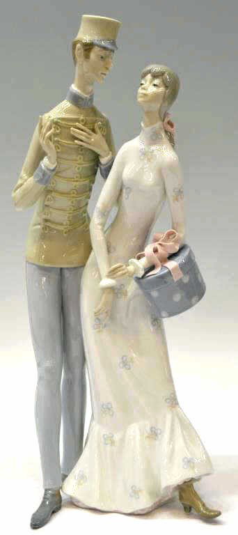 LLADRO PORCELAIN,'THE FLIRT,' #4564, RETIRED: Large Lladro porcelain figural group, "The Flirt," #4564, issued: 1970, retired: 1981, romantic marching band conductor with lady holding hatbox, flowing bow details, 17.25"h, 7"w, 6"d, 4.75lbs Start 