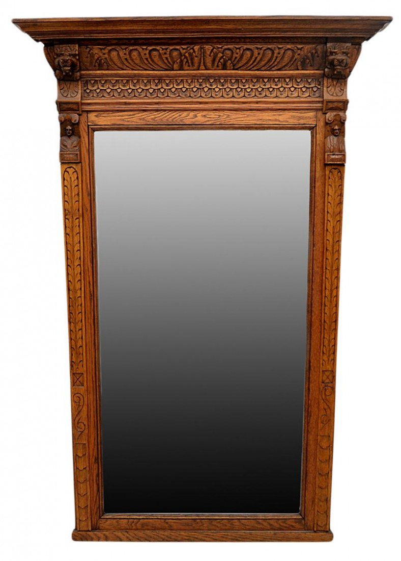 CARVED OAK FRAMED MIRROR, LIONS AND FIGURES: Oak framed mirror, likely Belgium, early 1900's, a stepped cornice with carved frieze flanked by lion's heads placed above the beveled mirror with two carved male busts, 56.75"h, 38"w, 4.75"d, 44lbs S