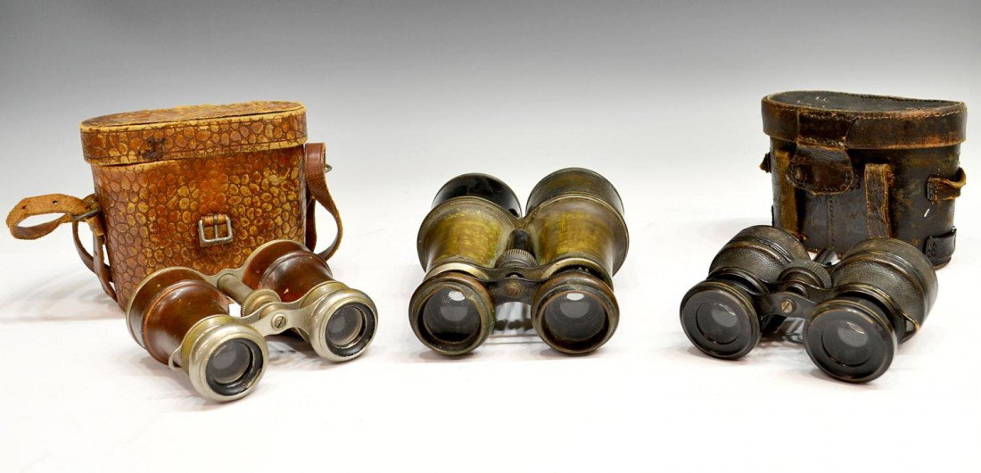 GROUP OF ANTIQUE FIELD BINOCULARS: (lot of 3) Antique field binoculars, two having leather covered sights and presented in leather cases, the largest with dent to end piece and loss, wear overall with age, largest: 6"h, 4.75"w, 4lbs to