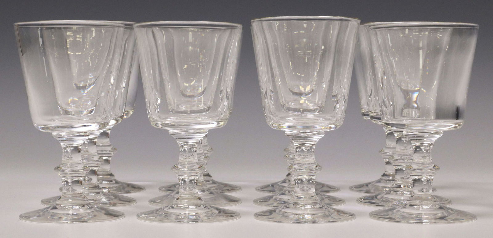 (12) STEUBEN ART GLASS 7725 CLARET WINE STEMS: (lot of 12) Steuben colorless glass claret wine stems, 20th c., pattern number 7725, designed by Sidney Waugh (American, 1904-1963), each with engraved signature underfoot, in original box, glasses: a