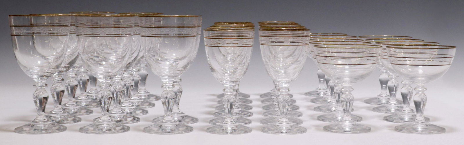 (33) GLASS STEMWARE SERVICE, TRIPLE GILT BANDS: (lot of 33) Glass stemware service, having three gilt trim bands, over baluster-form standard, including: (9) champagne glasses, approx 5"h, 4"diam, (12) white wine stems, approx 6"h, 3"diam, (12) red