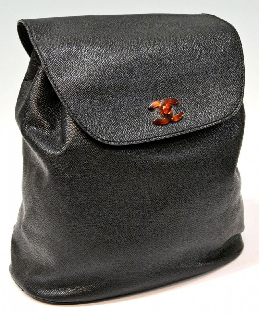 CHANEL LEATHER FAUX TORTOISE SHELL BACKPACK: Vintage Chanel black leather backpack having faux tortoise logo closure and hardware, #5513224 interior pocket on Chanel logo tag, wear to drawstring, stain on interior tag as pictured, 11"h, 10.75"w
