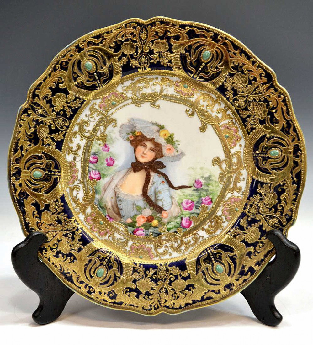 SCARCE HEAVILY GILT JEWELED NIPPON PORTRAIT PLATE: Nippon heavily gilded enameled porcelain portrait plate, c. 1900, one of the Four Seasons, the young beauty amid colorful roses, centered by a bejeweled cobalt border with raised enamel gilt detail, b