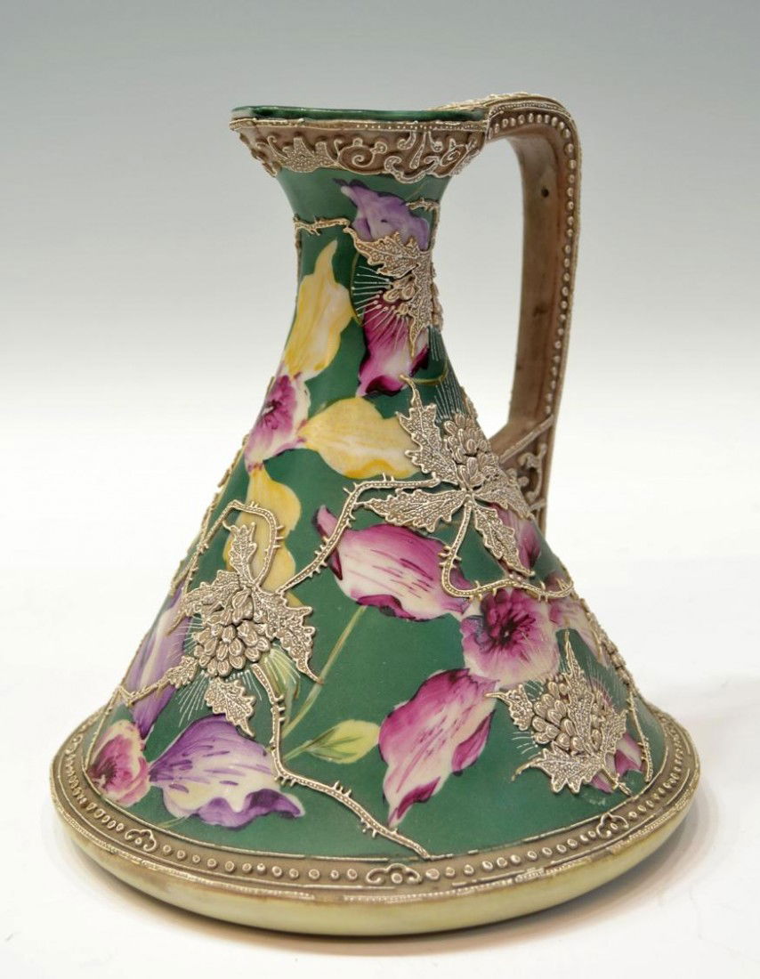 MORIAGE FLORAL DECORATED EWER ATTRIBUTED TO NIPPON: A moriage decorated ewer, attributed to Nippon, the green ground painted with vibrant purple flowers and applied with moriage flowering vines, some loss of moriage trim at base, on body, unmarked, 8"h