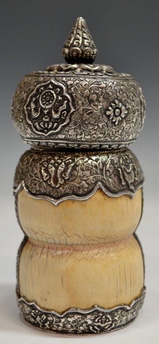 ASIAN SILVER MOUNTED IVORY JAR: ***This Item Will Not Be Shipped Internationally*** Southeast Asian silver mounted ivory jar, 19th c., the patinated ivory partial tusk carved in spool form encased by repousse worked silver frame hav