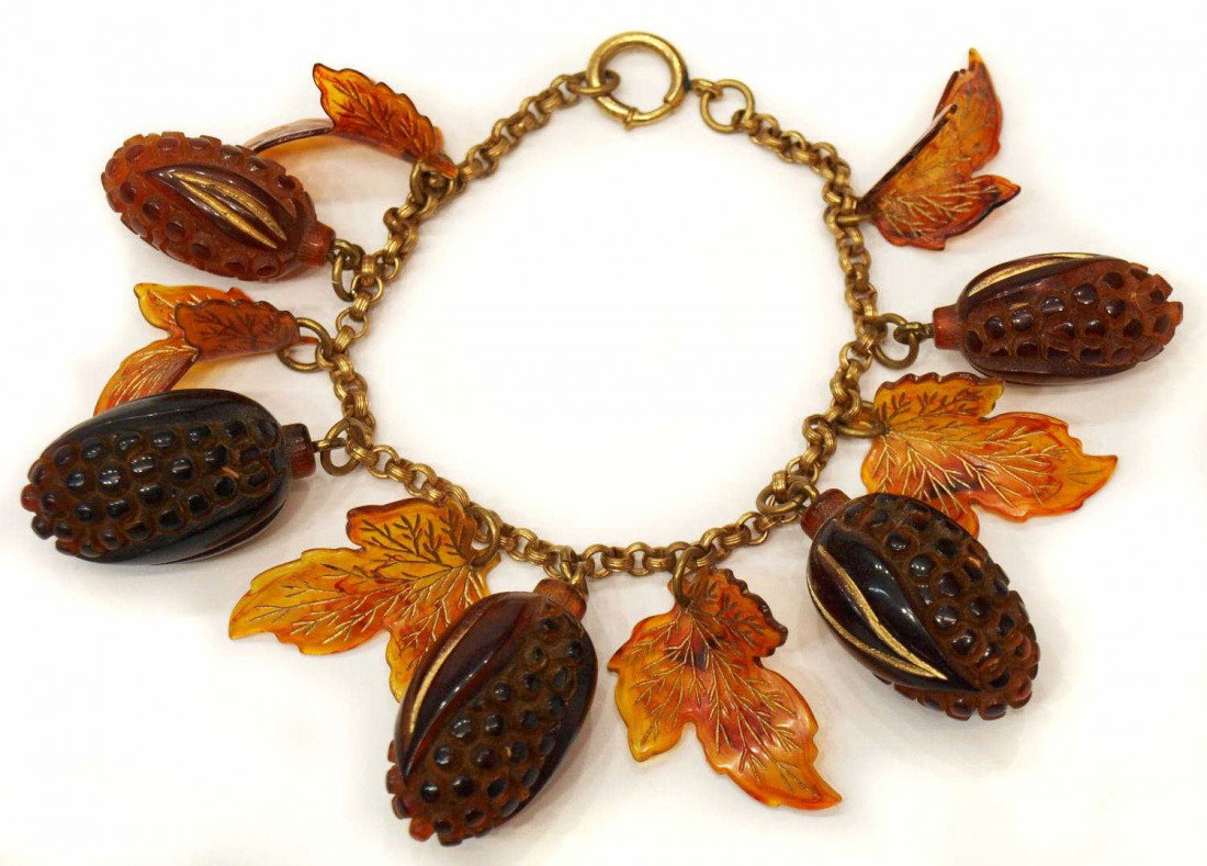 SCARCE BAKELITE PARCEL GILT FRUIT & LEAVE BRACELET: Scarce early bakelite amber / root beer bracelet, a gilt metal link chain hung with five parcel gilt veined leaves and five fruits with gilding, 8"l Start Price: $150.00