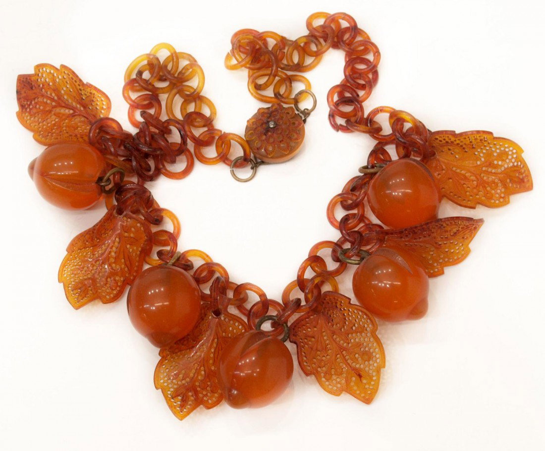 RARE AMBER ROOT BEER BAKELITE APRICOT NECKLACE: Rare and unusual vintage amber / root beer bakelite necklace, the circular linked chain hung with five apricots and six ornately pierced leaves, set with a conforming clasp, approx 22"l Start Price: $