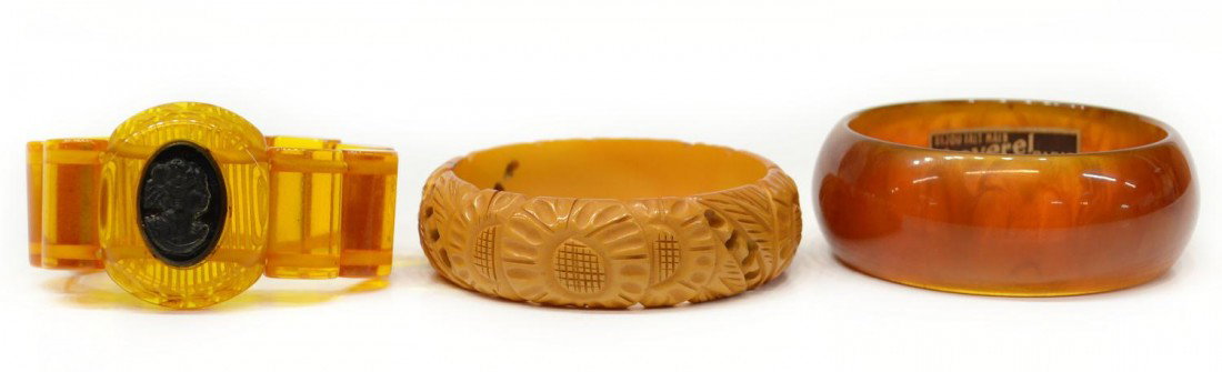 VINTAGE BAKELITE CARVED, CAMEO & FRENCH BRACELETS: (lot of 3) Vintage bakelite bracelets: (1) apple juice stretch bracelet having central reverse carved medallion set with a oval 'cameo'; (1) French root beer bangle, chunky, retaining 'Baverel Paris' 