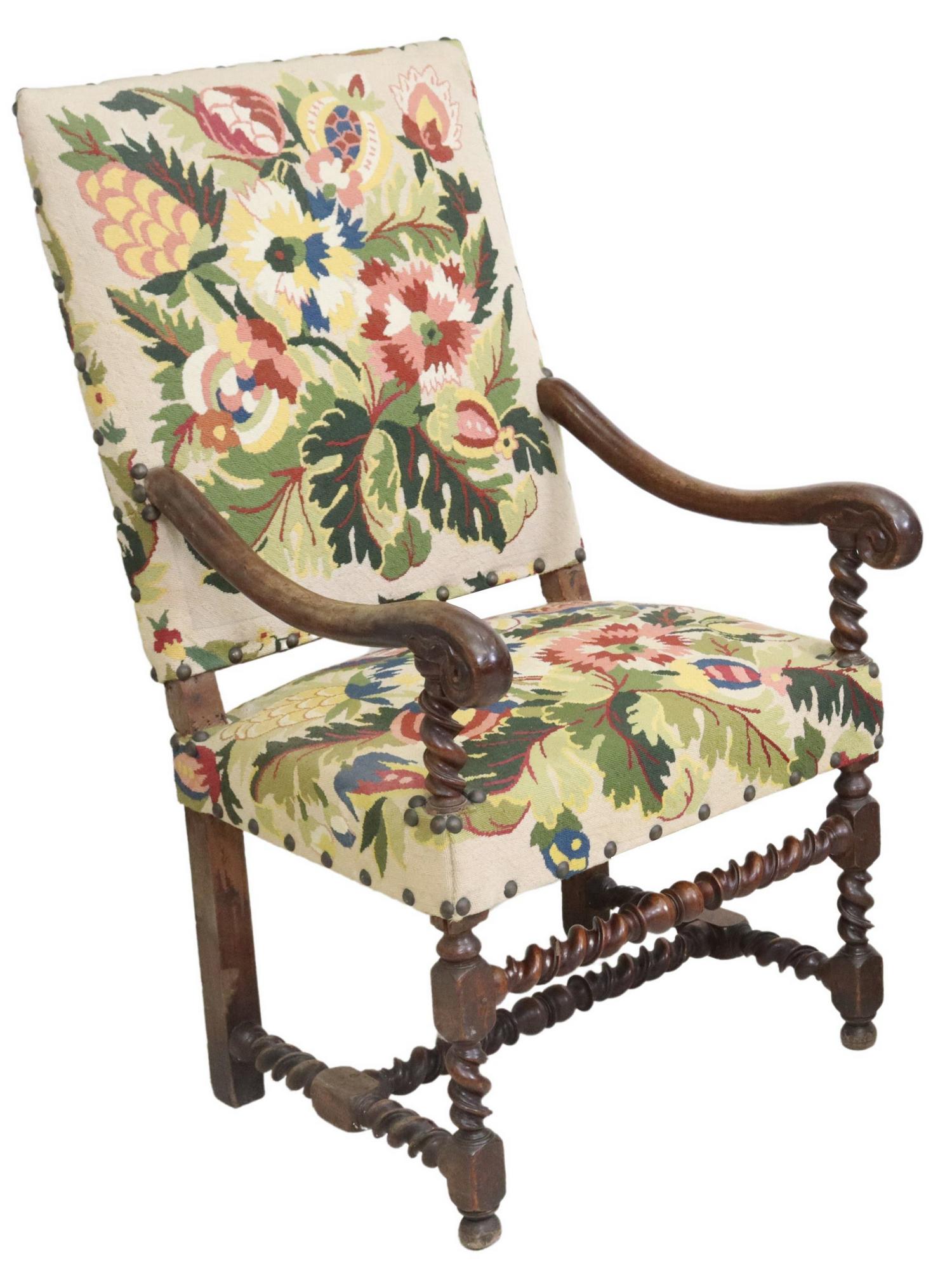 FRENCH LOUIS XIII STYLE HIGHBACK FAUTEUIL: French Louis XIII style highback armchair, 19th c., in a floral needlepoint upholstery, with nailhead trim, scrolled handholds, rising on turned legs, joined with H stretcher, ending on bun feet, appr