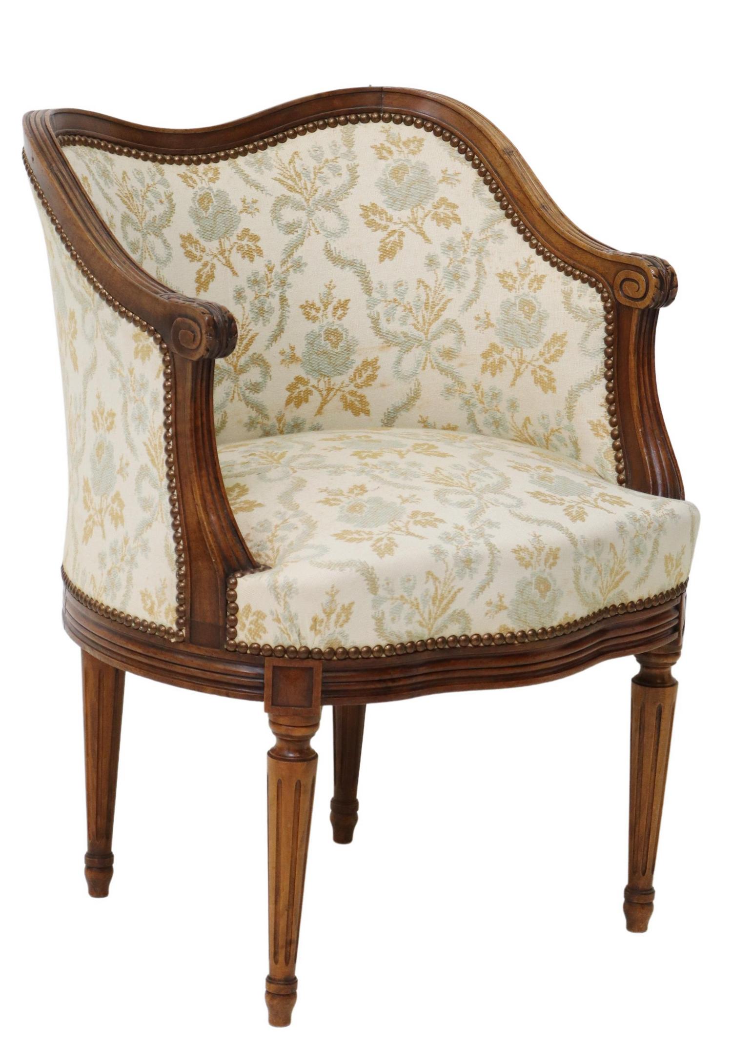 LOUIS XVI STYLE WALNUT FLORAL UPHOLSTERED BERGERE: Louis XVI style carved walnut bergere/ armchair, late 19th c./early 20thc., having molded frame, in floral patterned upholstery, nailhead trim, scrolled handholds, rising on fluted tapered supports, s