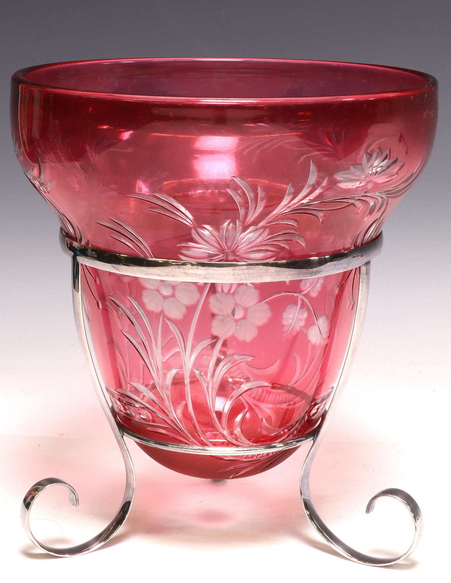 CRANBERRY CUT-TO-CLEAR GLASS BASE ON METAL STAND: Cranberry cut-to-clear glass centerpiece vase, early 20th c., of tapered form, with foliate motifs and frosted flowers, rising on silverplate metal tripartite base, ending on scrolled feet, approx 10.