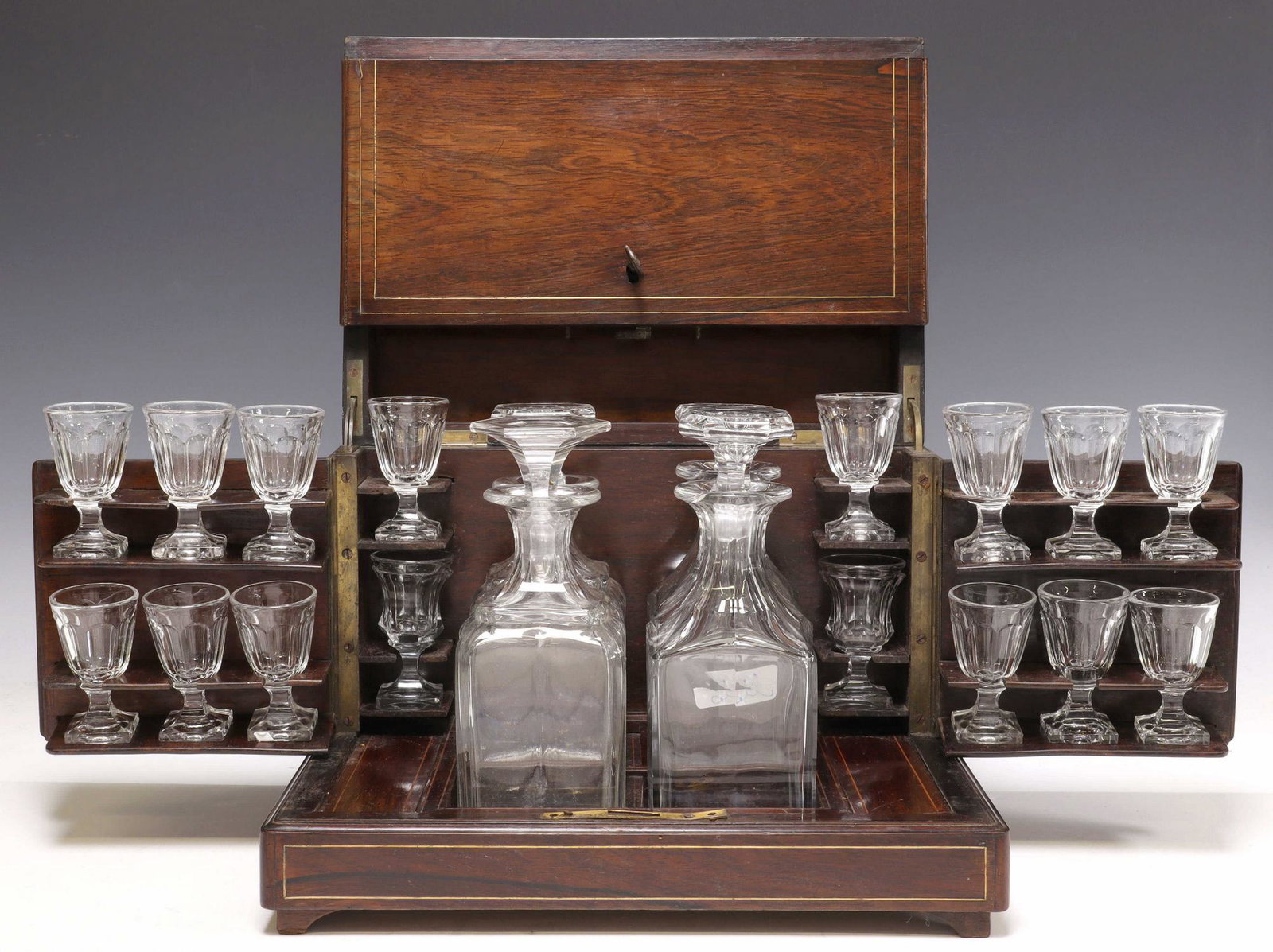 FRENCH NAPOLEON III PERIOD CAVE A LIQUEUR: French Napoleon III period cave a liqueur, late 19th c., having hinged top with string inlay, opening to sectioned interior fitted with (four) decanters with stoppers, (fourteen) matched cordial glass