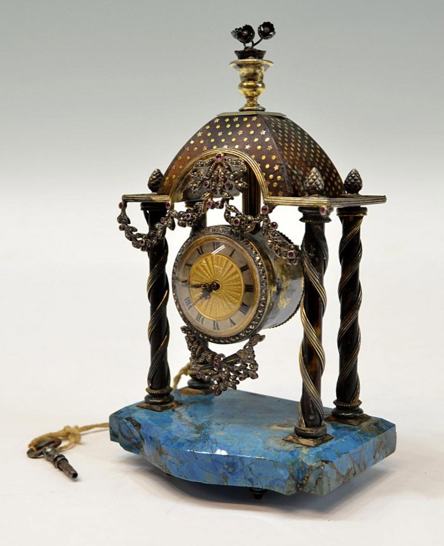 ANTIQUE VIENNESE GEMSET LAPIS & MARCASITE CLOCK: Viennese gemset and marcasite dresser clock having tortoise shell pillars mounted with fancy silver wire, the architectural top set with gilded stars, a gemset floral basket finial above, the base of 