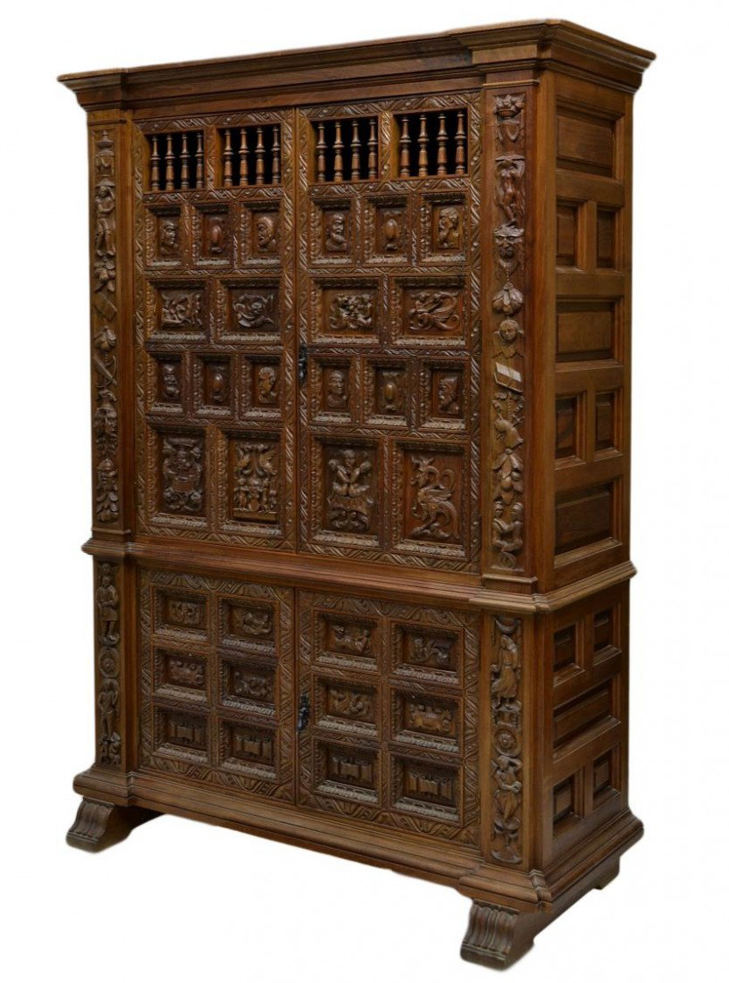 SPANISH BAROQUE STYLE CARVED PANELED CABINET: Spanish walnut cabinet, Barcelona, 20th c., a stepped cornice over two long doors and two lower short doors, each door with multiple panels having carving with mythical and historical figures, foliate