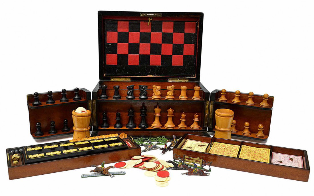 FINE 19TH C ENGLISH FITTED TRAVELING GAMES BOX: A Scarce Victorian walnut traveling game box, 19th c., lift top and fold out doors fitted with games having wood and ivory playing pieces, The Steeple Chase game with fold out board and lead horse fig